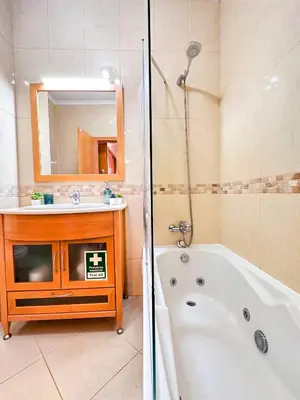a bathroom with a tub and a sink and a mirror at AlbufeiraOrada Cozy&Sunny Condo by BeCherish in Albufeira