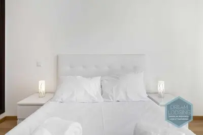 a white bed with white pillows and a table at Miguel Torga - Dream Lodging in Albufeira