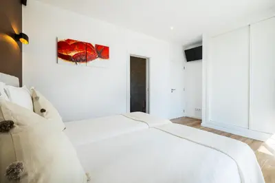 a white bedroom with a large white bed at Villa Kambole in Albufeira