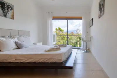 a bedroom with a large bed and a large window at Monte Balaia AT19 Duplex - Pool View Olhos de Agua in Olhos de Água