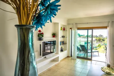 a vase with flowers in a room with a fireplace at Monte Balaia AT19 Duplex - Pool View Olhos de Agua in Olhos de Água