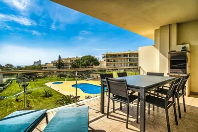 a patio with a table and chairs on a balcony at Monte Balaia AT19 Duplex - Pool View Olhos de Agua in Olhos de Água