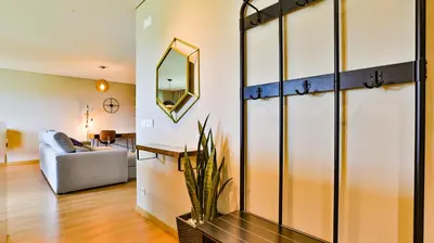 a living room with a couch and a mirror at Apartamento T2 novo e espaçoso em Vilamoura in Vilamoura