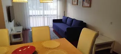 a living room with a table and a blue couch at Albufeira INN - Lote 6 T1 in Albufeira