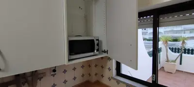 a kitchen with a microwave and a window at Albufeira INN - Lote 6 T1 in Albufeira