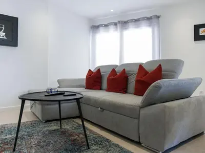 a couch with red pillows and a table in a living room at Panoramic E Apartment by Stay ici Algarve Holiday Rental in Albufeira