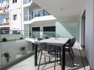 a balcony with a black table and chairs on a building at Panoramic E Apartment by Stay ici Algarve Holiday Rental in Albufeira