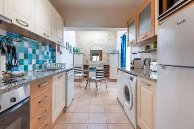 a kitchen with white cabinets and a washer and dryer at Cozy 2 BDR W/Balcony in Vale do Lobo by LovelyStay in Vale do Lobo