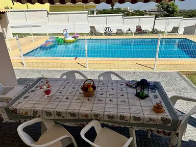 a row of chaise lounges next to a pool at Villa Belavista - Moradia para Famílias in Albufeira