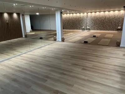 a large room with a large wooden floor and mirrors at Al Karob Yoga Boutique Hotel in Guia