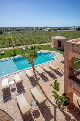 a swimming pool with chaise lounges and a resort at Al Karob Yoga Boutique Hotel in Guia