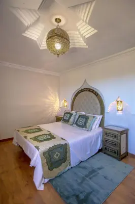 a bedroom with a bed and a dresser and a ceiling at Al Karob Yoga Boutique Hotel in Guia