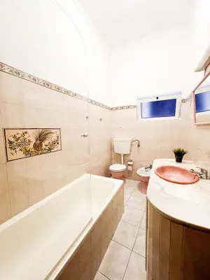 a bathroom with a tub and a sink and a toilet at Casa Brito in Albufeira
