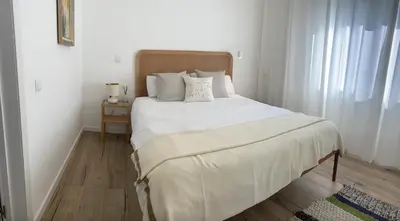 a bed with white sheets and pillows in a bedroom at Villa Amêndoa in Loulé