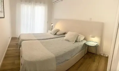 a bedroom with a large white bed with two pillows at Villa Amêndoa in Loulé
