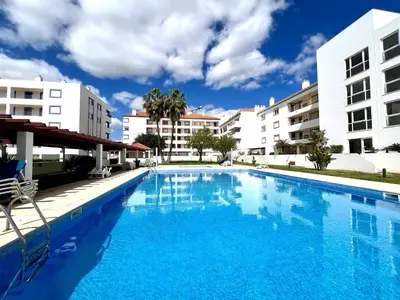 a large blue swimming pool with buildings in the background at Vilamoura Marina Charming With Pool by Homing in Vilamoura