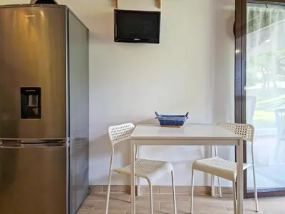 a table with two chairs and a refrigerator at APART ALDEIA DAS AÇOTEIAS - T0 - By BEDZY in Albufeira