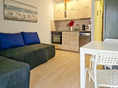 a living room with a couch and a kitchen at APART ALDEIA DAS AÇOTEIAS - T0 - By BEDZY in Albufeira