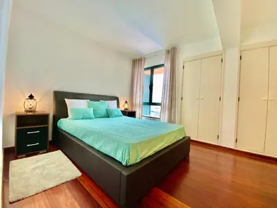 a bedroom with a bed with blue sheets and a window at Marina Garden by Ethnic Ocean in Vilamoura
