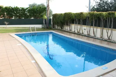 a swimming pool with blue water in a yard at Vila Montechoro in Albufeira