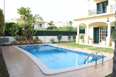 a swimming pool in a yard next to a house at Vila Montechoro in Albufeira