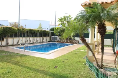 a swimming pool in a yard with palm trees at Vila Montechoro in Albufeira