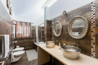 a bathroom with a sink and two mirrors on the wall at VILA RUINAS GAMITO in Guia