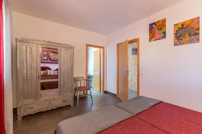 a bedroom with a bed and a wooden cabinet at VILA RUINAS GAMITO in Guia
