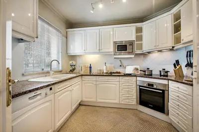 a white kitchen with white cabinets and a sink at Mng Elliott52 in Vale do Lobo