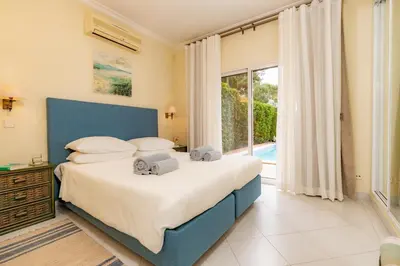 a bedroom with a bed and a large window at Mng Elliott50 in Vale do Lobo