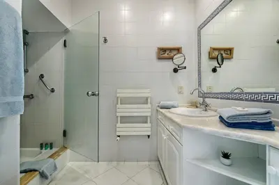 a white bathroom with a shower and a sink at Mng Elliott50 in Vale do Lobo