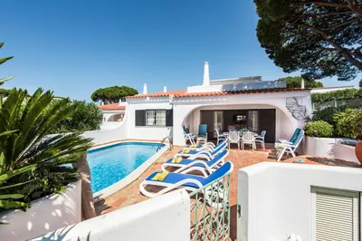 a swimming pool with chairs and a house at Mng Elliott25 in Vale do Lobo