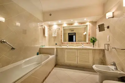 a bathroom with a tub and a sink and a mirror at Mng Elliott24 in Vale do Lobo