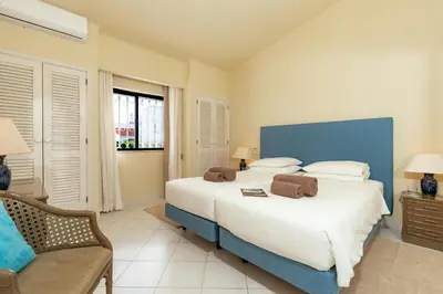 a bedroom with a large bed and a chair at Mng Elliott24 in Vale do Lobo