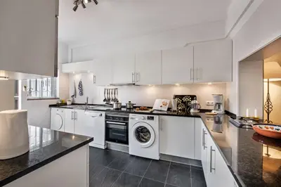 a kitchen with white cabinets and a washer at Mng Elliott76 in Vale do Lobo