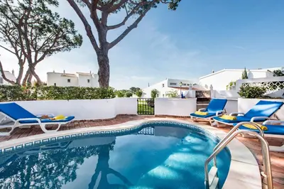 a swimming pool with lounge chairs and a swimming poolvisorvisor at Mng Elliott72 in Vale do Lobo
