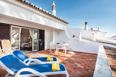 a room with a table and chairs on a balcony at Mng Elliott72 in Vale do Lobo