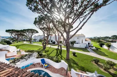 a patio with blue chairs and a table on a house at Mng Elliott72 in Vale do Lobo