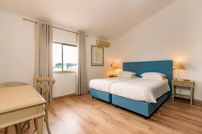 a bedroom with a blue bed and a table and a desk at Mng Elliott91c in Vale do Lobo