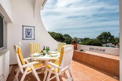 a patio with a table and chairs on a balcony at Mng Elliott91c in Vale do Lobo
