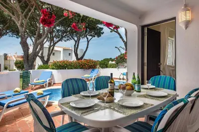 a dining room with a table and chairs on a patio at Mng Elliott71 in Vale do Lobo