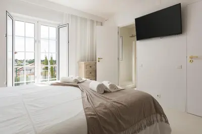 a white bedroom with a bed with towels on it at Modern retreat 3 Bedroom in Vilamoura in Quarteira