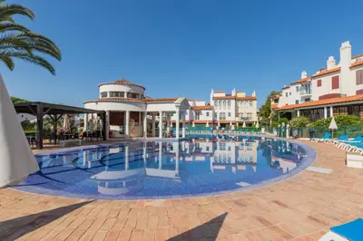 a pool at a resort with chairs and buildings at Modern retreat 3 Bedroom in Vilamoura in Quarteira