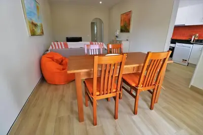 a dining room table with four chairs and a couch at Apartamento laranja Quarteira in Quarteira