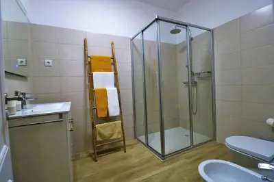 a bathroom with a shower and a toilet and a sink at Apartamento laranja Quarteira in Quarteira