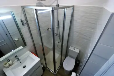 a bathroom with a shower and a toilet and a sink at Apartamento laranja Quarteira in Quarteira