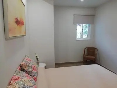 a white room with a bed and a window at Apartamento laranja Quarteira in Quarteira
