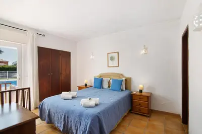 a bedroom with a blue bed with towels on it at Villa Aveiros in Albufeira