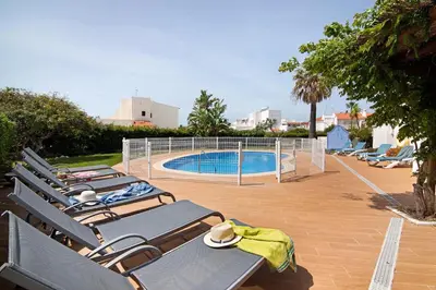 a row of lounge chairs next to a swimming pool at Villa Aveiros in Albufeira