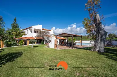 a house with a large yard with a pool at #213 Vila Roja Pé by Home Holidays in Albufeira